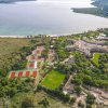 Vista aerea su campi da tennis, un edificio e un lago.