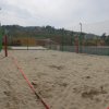 Campo da beach volley con sabbia e recinzione.