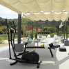 Area fitness all'aperto con attrezzi e pergolato.