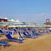 Lettini e ombrelloni su una spiaggia di sabbia.