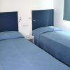 Camera con due letti singoli coperti di blu.
