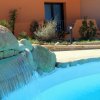 Una cascata d'acqua in una piscina vicino a un edificio arancione.