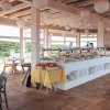 Ristorante luminoso con buffet, sedie e vetrate panoramiche.