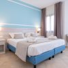 Camera con letto matrimoniale, testata azzurra e comodini.