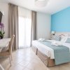Camera con letto matrimoniale, parete azzurra e TV a muro.