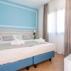 Camera da letto con pareti azzurre, letto matrimoniale e un'orchidea su mensola.
