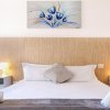 Letto con lenzuola bianche e quadri blu sopra.