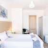 Interno di una camera da letto luminosa con letto matrimoniale e arredo moderno.