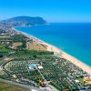 Vista aerea di una spiaggia e un villaggio turistico vicino al mare.