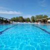 Piscina blu con sedie a sdraio intorno.