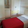 Camera singola con letto rosso e armadio chiaro.