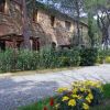Struttura in pietra lungo un sentiero con fiori gialli e rossi.