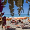 Spiaggia con ombrelloni gialli e arancioni, vista mare.