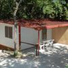 Casa prefabbricata circondata da alberi e sedie all'esterno.