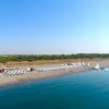 Spiaggia con sedie a sdraio e barche a vela, vista aerea.