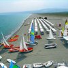 Barche a vela e ombrelloni su una spiaggia sabbiosa.
