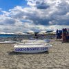 Spiaggia con lettini, ombrelloni e una barca.