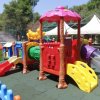 Area giochi colorata con scivoli e recinzione.