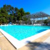 Piscina con sdraio e ombrelloni in un'area soleggiata.