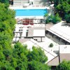 Visione aerea di un complesso con piscina circondato da alberi.