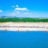 Spiaggia con ombrelloni, sedie e mare calmo.