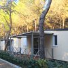 Bungalow beige immerso in una pineta.