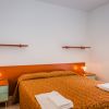 Camera con letto matrimoniale e comodini verdi.
