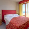 Camera da letto con testiera rossa e finestra vista mare.