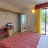 Camera con letto rosso, scrivania e balcone.