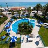 Vista aerea di piscina, giardino e spiaggia.