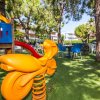 Area giochi per bambini con altalena e giochi colorati.