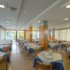Sala da pranzo con tavoli apparecchiati e ampie finestre.