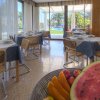 Sala da pranzo luminosa con tavoli apparecchiati e vista giardino.