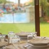 Tavolo apparecchiato vicino a una vetrata con vista piscina.