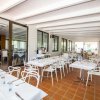 Veranda con tavoli apparecchiati e sedie bianche.