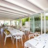Sala da pranzo elegante con tavoli imbanditi e sedie bianche.