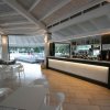 Bar moderno con sedie bianche e vista sulla piscina.