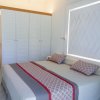 Letto matrimoniale davanti a un armadio bianco.