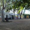 Caravan e tenda con area picnic tra gli alberi.