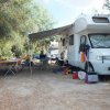 Camper parcheggiato con tavoli e sedie fuori.