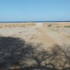 Sentiero sabbioso verso la spiaggia deserta.