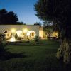 Edificio con archi illuminato di sera, giardino e fontana.