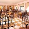 Ristorante vuoto con sedie nere e tavoli in legno.