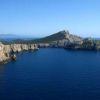 Capi rocciosi con una piccola insenatura e mare blu.