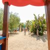 Parco giochi con scivoli e vegetazione.