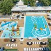 Piscina con giochi d'acqua e lettini bianchi.