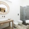 Un bagno moderno con doccia e specchio rotondo.