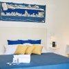 Camera da letto con letto blu e cuscini gialli.