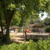 Persone giocano a ping pong e pallavolo all'aperto.