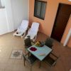 Patio con sedie a sdraio e tavolo, frutta al centro.